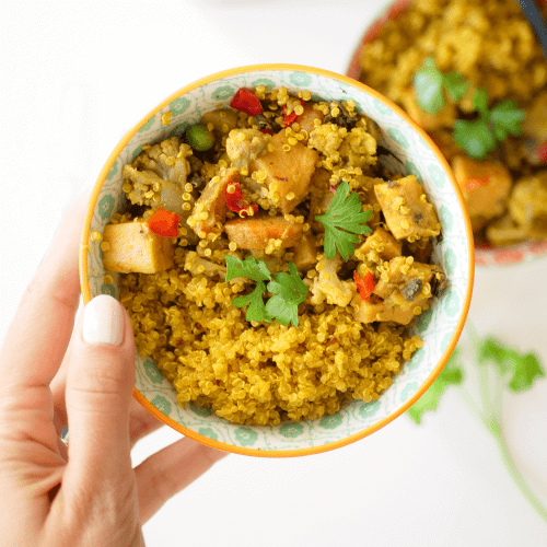 ALOO GOBI GRAIN BOWL IN A DISH ON A WHITE BACKGROUND.