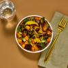 Roasted Brussels Sprout Bowl with napkin, fork, and glass of water on brown table