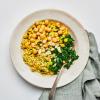 Coconut Curry Rice Bowl on a white table with a silver fork and green napkin