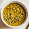 White bowl of Green Split Pea Soup Soup on white background.