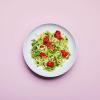 Kale Pesto Noodles in a dish on a pink background.