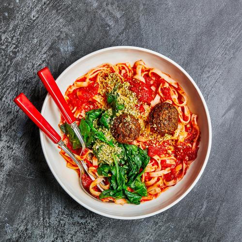 Vegan Meatballs & Marinara Noodles on a black table