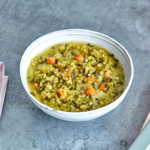 Masala Khichri Soup in a white bowl on a gray background.