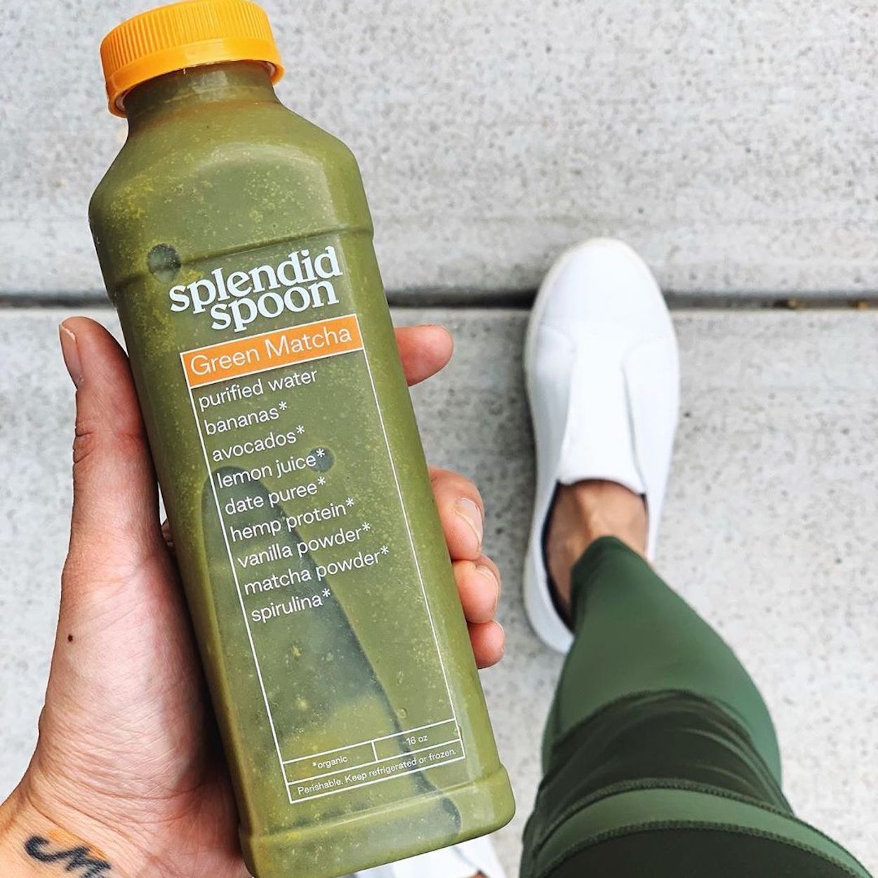 We are looking down from the perspective of a woman walking down the street with a smoothie in her hand.